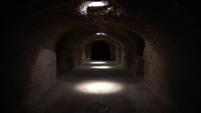 Pass through a long and dark Roman basement. Basement under the Amphitheater in El Jem, Tunis. Ancient roman building. The camera is approaching