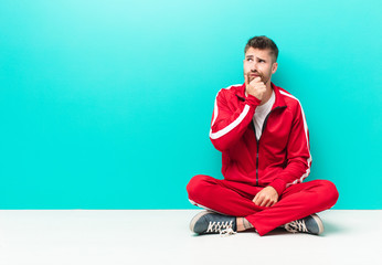 young handosme man thinking, feeling doubtful and confused, with different options, wondering which...