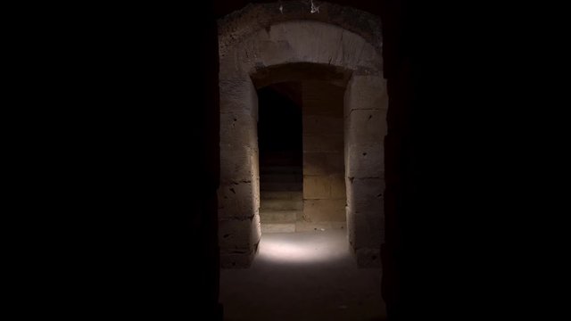 Pass through a long and dark Roman basement. Basement under the Amphitheater in El Jem, Tunis. Ancient roman building. The camera is approaching