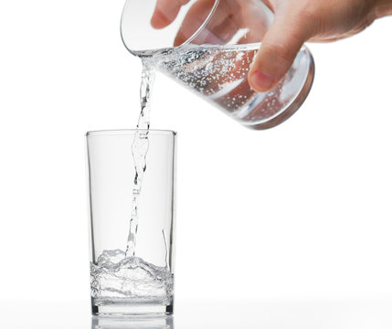 pouring sparkling water in a glass on white background, isolated object