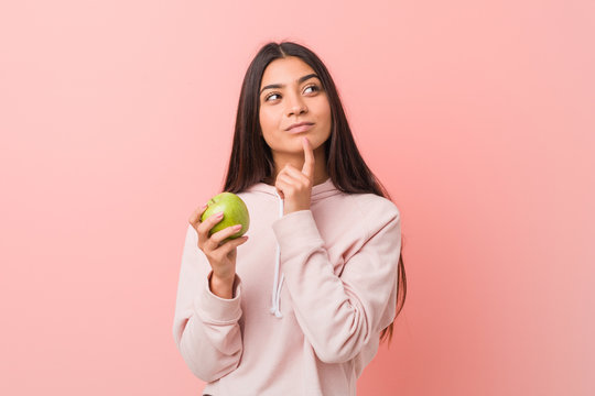 young indian woman holding an apple