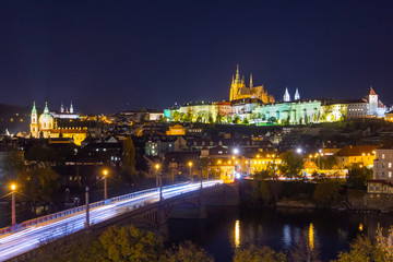 Fototapeta na wymiar Colorful Prague Castle above the River Vltava at night. Cityscape with car light trails.