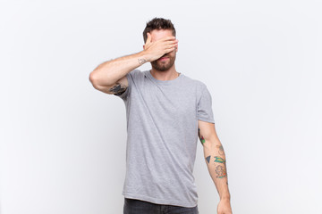 young handosme man covering eyes with one hand feeling scared or anxious, wondering or blindly...