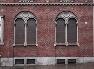Fototapeta na wymiar brick facade with mullioned window framed by a second arch in which a coat of arms has been inserted