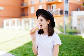 Fototapeta premium Young woman in hat enjoy ice cream on the street