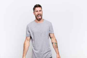 young handosme man with cheerful, carefree, rebellious attitude, joking and sticking tongue out,...