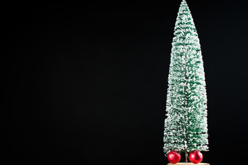 Christmas tree sprinkled with snow. Sweets that are wrapped in a red wrapper.