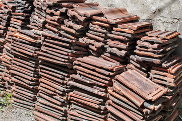 Stack of old used red terracotta Mediterranean ceramic roof tiles closeup