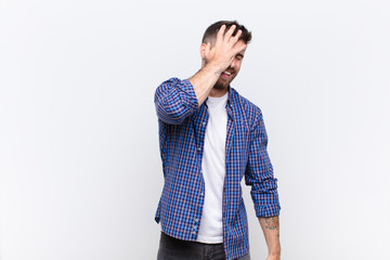 young handosme man laughing and slapping forehead like saying d‚Äôoh! I forgot or that was a...
