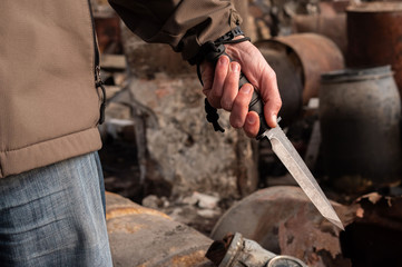 A man holds a knife in his hand. Big bayonet knife in the hand.