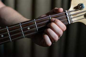 hand playing bass guitar close up