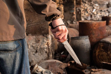A man holds a large knife. The military holds a knife.