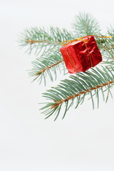 Merry christmas and a happy new year! The atmosphere of the winter holidays. Green spruce branch with decorations on a light background and free space for an inscription.