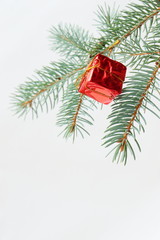 Merry christmas and a happy new year! The atmosphere of the winter holidays. Green spruce branch with decorations on a light background and free space for an inscription.