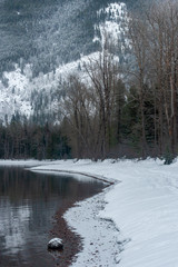 Cold winter lake in a mountain valley. Winter holiday hiking adventure. 