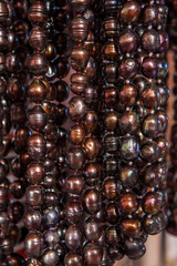 Beautiful dark pearly beads hanging on strings.