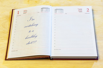 The diary is on the table. The diary is open on the first of January page. The page reads: 