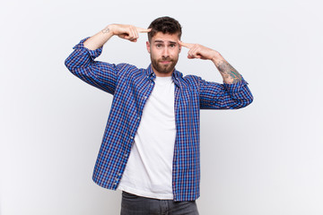 young handosme man with a serious and concentrated look, brainstorming and thinking about a...