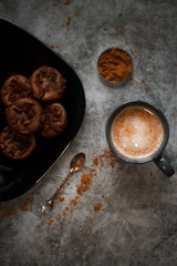 cocoa drink in blue mug with chocolate on dark textured background with chocolate muffins and vintage spoon and cocoa powder.
