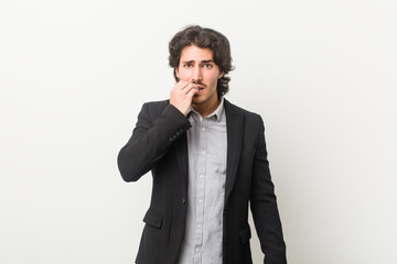 Young business man against a white background biting fingernails, nervous and very anxious.