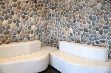 two white sofas against a stone wall