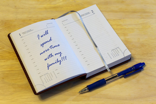 The diary is on the table. The diary is open on the first of January page. On the page it is written: "I will spend more time with my family!!!".