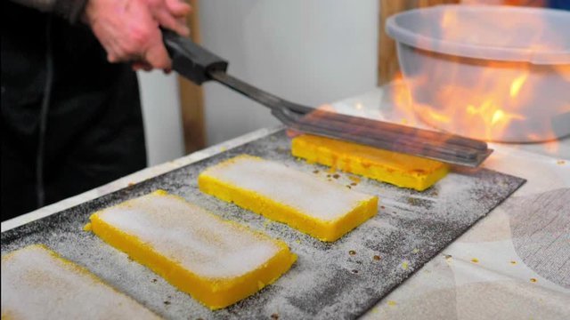 Plancha de cocinero en primer plano quemando pastillas de turr&oacute;n de yema