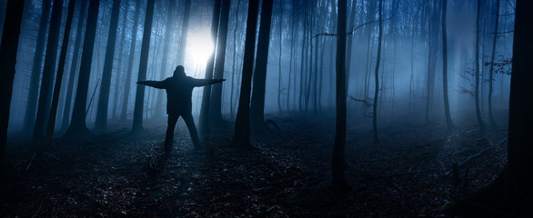 one alone man in a dark foggy forest