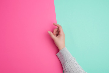 female hand on a green background, fingers in the gesture of holding the subject