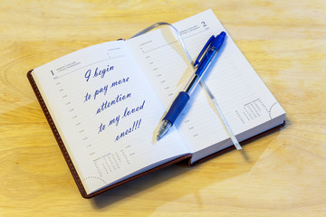 The diary is on the table. The diary is open on the first of January page. On the page it is written: "I begin to pay more attention to my loved ones!!!".