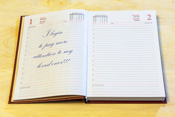 The diary is on the table. The diary is open on the first of January page. On the page it is written: 