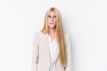 Young business blonde woman on white background confused, feels doubtful and unsure.