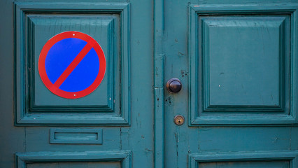 No parking sign. Circle red and blue no parking sign on door. Restrictive Regulatory sign. Road...
