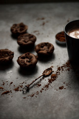 on a dark textured background with chocolate muffins and vintage spoon and cocoa powder.