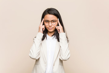 Young business chinese woman focused on a task, keeping forefingers pointing head.