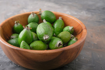 Feijoa fruit in a wooden plate on the table.