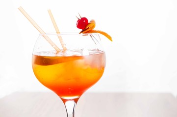 refreshing aperol cocktail garnished with orange shell and cherry