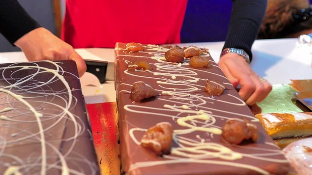 Chef cortando con cuchillo tarta de navidad de turr&oacute;n decorada