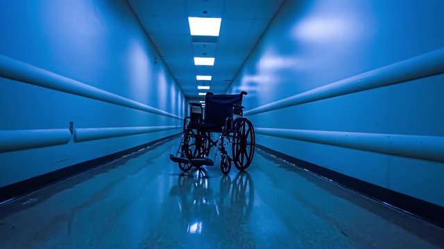 Approaching an empty wheelchair sitting in an empty hospital corridor; 4k dolly shot
