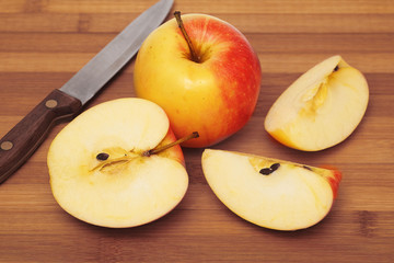 Naklejka na ściany i meble Whole apple and cut up apple on cutting board