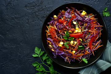 Red cabbage salad cole slaw with carrot and cucumber in a bow. Top view. - obrazy, fototapety, plakaty