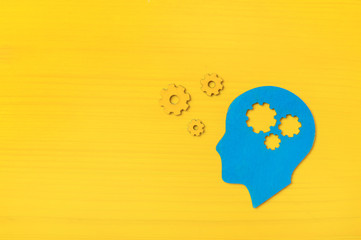 Brain works concept. Thinking, creativity concept of the human head with gears on yellow background