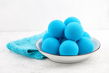 Blue bath bombs in plate on white tabletop