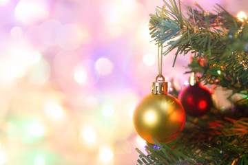 Christmas decoration. Hanging gold balls on pine branches Christmas tree garland and ornaments over abstract bokeh background with copy space.