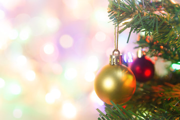 Christmas decoration. Hanging gold balls on pine branches Christmas tree garland and ornaments over abstract bokeh background with copy space.