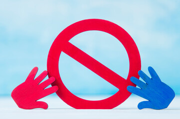 Red forbidden sign and hand  on blue background.