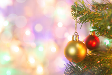 Christmas decoration. Hanging gold balls on pine branches Christmas tree garland and ornaments over abstract bokeh background with copy space.