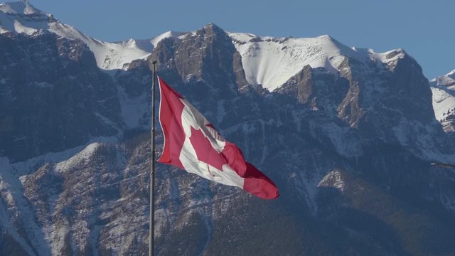 Canadian Flag Blowing in the Wind with Rocky Mountains in the Background, West Coast, Banff, Canmore, Alberta, Canada