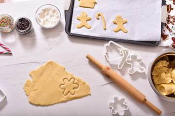 Christmas and New Year celebration traditions. Family home bakery, cooking traditional festive sweets. Woman cutting cookies of raw gingerbread dough