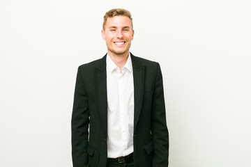 Young caucasian business man laughs and closes eyes, feels relaxed and happy.